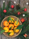 Basket of ripe mandarins, spruce branches and christmas toy on a wooden background. selective focus. Royalty Free Stock Photo