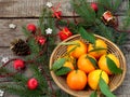 Basket of ripe mandarins, spruce branches and christmas toy on a wooden background. selective focus. Royalty Free Stock Photo