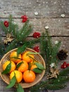 Basket of ripe mandarins, spruce branches and christmas toy on a wooden background. selective focus. copy space Royalty Free Stock Photo