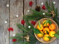 Basket of ripe mandarins, spruce branches and christmas toy on a wooden background. selective focus. copy space Royalty Free Stock Photo