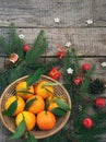 Basket of ripe mandarins, spruce branches and christmas toy on a wooden background. selective focus. copy space Royalty Free Stock Photo