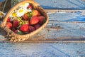 Basket with ripe strawberries and white camomiles on old blue paint wooden background Royalty Free Stock Photo