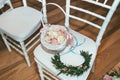 Basket with rose petals on white chair on wedding ceremony