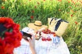 Basket, sandwiches, plaid and juice in a poppy field. Vintage te