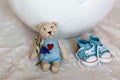 Basket shell of Easter eggs, flat shoes baby boy and a teddy bear with a heart close-up, requisites for a photo session of a newbo Royalty Free Stock Photo