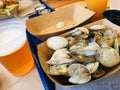 basket of steamers clams and glass of beer