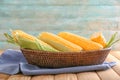 Basket with tasty corncobs on wooden table Royalty Free Stock Photo