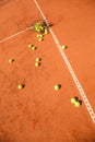 Basket of tennis balls scattered around the court Royalty Free Stock Photo