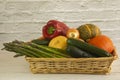 In a basket there are courgettes, carrots, pumpkins, peppers, onions and asparagus from the garden