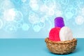 Basket with three colorful terry towels or cosmetic for body care on a blue table over blue background with copy space. For your Royalty Free Stock Photo