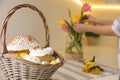 Basket with traditional Easter cakes and dyed eggs on table indoors, space for text Royalty Free Stock Photo