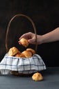 Basket with Traditional French Gougeres - savory cheese pastry and female hand taking one of the buns Royalty Free Stock Photo