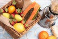 Basket of tropical fruits, oranges, pears kiwi papaya with a mixer on a wooden table. horizontal Royalty Free Stock Photo