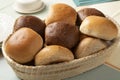 Basket with a variation of white and brown buns of bread close up
