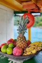 Basket of various fruits on a wooden boat on the high seas on a sunny day with an orange buoy hanging in the background