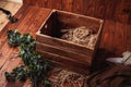 Basket on a wooden floor. Props for newborn photography. Brown basket with dark green branch. Newborn photography backdrop