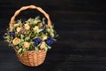 Basket with yellow and blue wizened flowers on dark wooden background, copy space Royalty Free Stock Photo