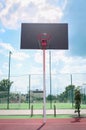 Basketball backboard with a basket made of iron chains on a sunny day. Royalty Free Stock Photo
