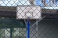 Basketball backboard behind steel fence net