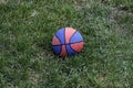 Basketball ball waiting for children. Green grass and worn basketball ball. Royalty Free Stock Photo