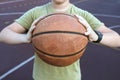 Basketball ball in the hands of a teenager, close up. Healthy lifestyle and sport concepts