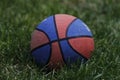 Basketball ball waiting for children. Green grass and worn basketball ball. Royalty Free Stock Photo