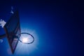 Basketball basket from below outside with an intense sun and blue sky Royalty Free Stock Photo
