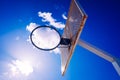 Basketball basket on an outdoor court with an intense sun with dark blue cloud sky, copy space Royalty Free Stock Photo