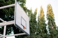 The basketball board is made of wood with a broken basket ring