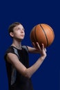 Basketball. The guy in the black T-shirt is preparing to throw the ball. Blue background. Teen basketball player
