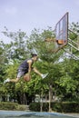 Basketball in hand man jumping Throw a basketball hoop Background tree in park