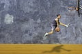 Basketball in hand man jumping Throw a basketball hoop On the wooden floor Background plaster wall loft with The pattern of