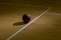 Basketball On Hardwood Court Floor With Spot Lighting