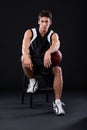 Basketball is his thing. Full length studio portrait of a male basketball player sitting with the ball under his arm. Royalty Free Stock Photo