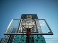 Basketball hoop against a blue sky and high-rise building. Sports ground, workout near the house. Healthy lifestyle