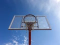 Basketball hoop with net on an outdoor court with sky background from below Royalty Free Stock Photo