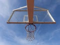 Basketball hoop with net on an outdoor court with sky background from below Royalty Free Stock Photo