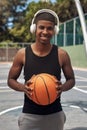 Basketball is my craft. Portrait of a sporty young man listening to music while playing basketball on a sports court. Royalty Free Stock Photo