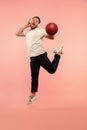 Full length portrait of young successfull high jumping man gesturing isolated on pink studio background Royalty Free Stock Photo