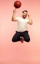 Full length portrait of young successfull high jumping man gesturing isolated on pink studio background Royalty Free Stock Photo