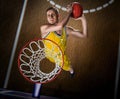 Basketball player making slam dunk on basketball arena