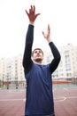 Basketball player in the open stadium trains, performed a throw, raising his hands. Royalty Free Stock Photo