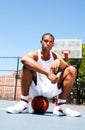 Basketball player sitting on ball Royalty Free Stock Photo