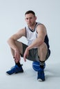 Basketball player sitting on ball Royalty Free Stock Photo