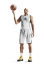 Basketball player spins the ball on his finger. Professional basketball player standing in white background Royalty Free Stock Photo