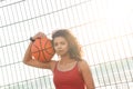 Basketball Player. Woman standing holding ball on court leaning back pensive close-up Royalty Free Stock Photo