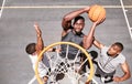 Basketball players blocking a player from dunking a ball into net to score points during a match on sports court from Royalty Free Stock Photo