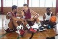 Basketball players interacting while relaxing in the court Royalty Free Stock Photo