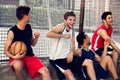 Basketball players take a break sitting on a low wall Royalty Free Stock Photo