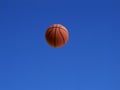 A basketball shot in the air with blue sky background